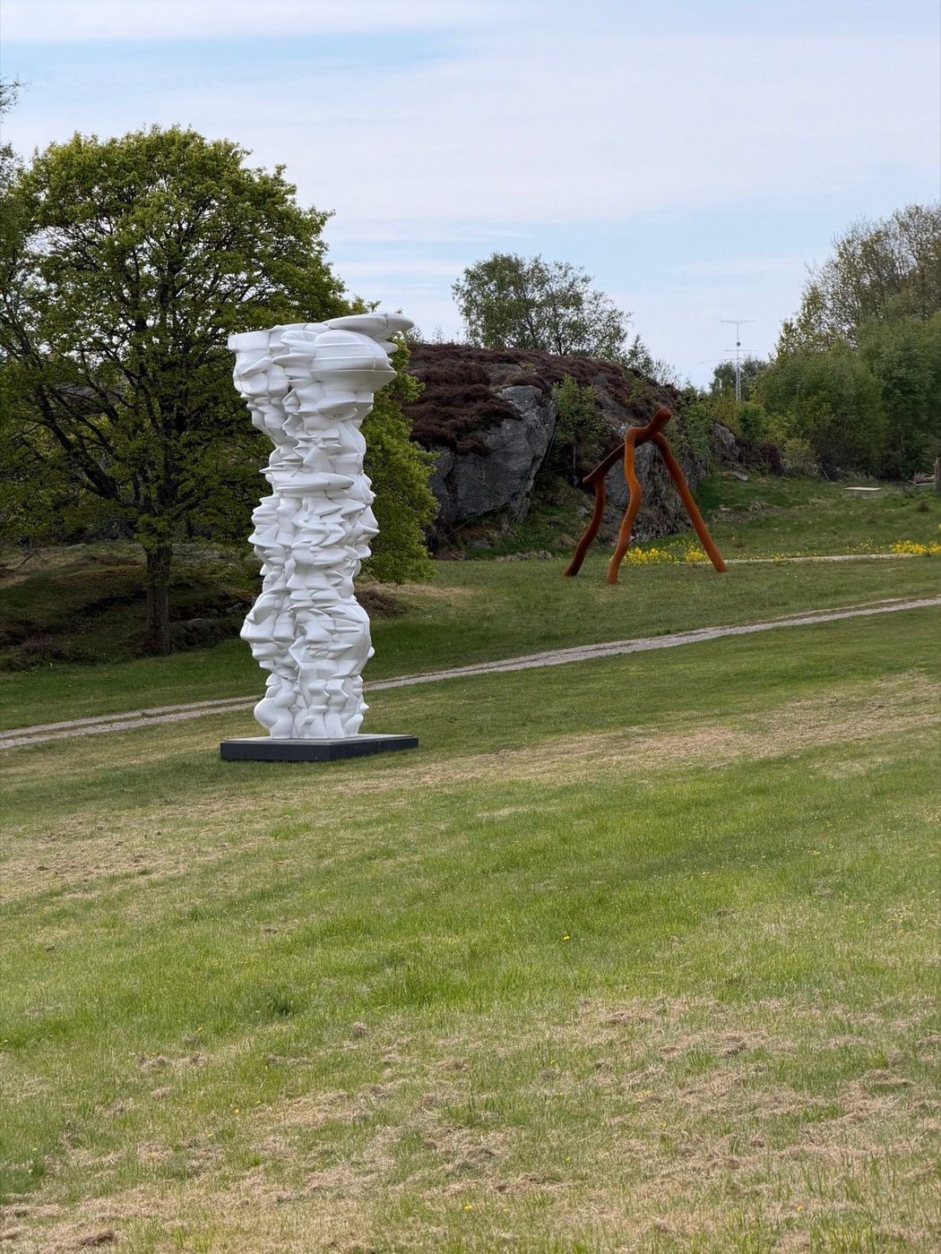 Tony Cragg, sculpture in the landscape — white column and Corten figure.